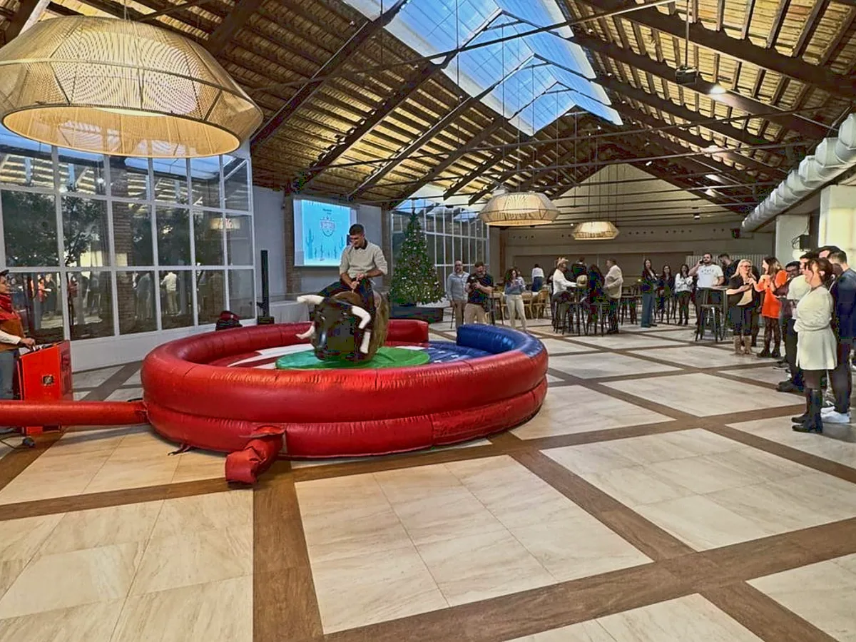 Toro mecánico instalado dentro de un salón grande en un evento de empresa
