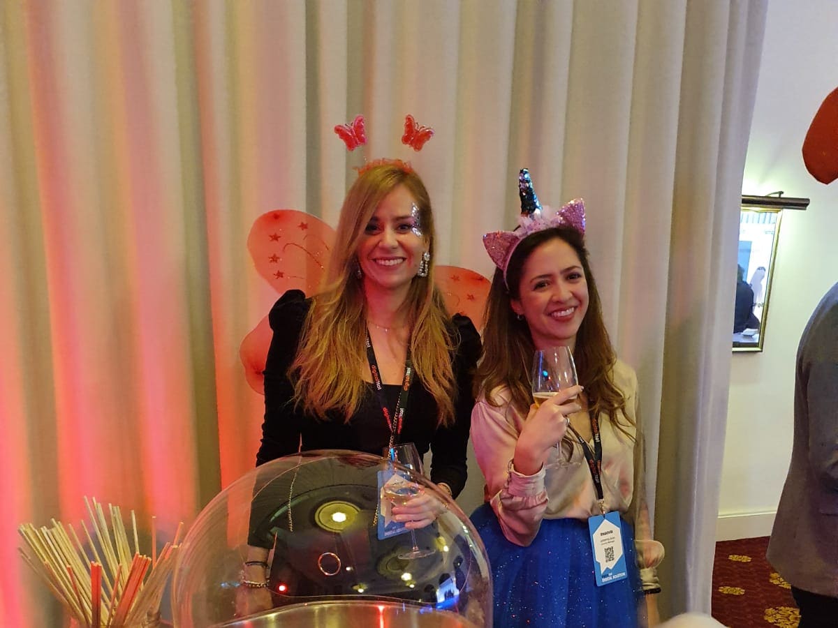 Invitadas sonriendo junto al carrito de algodón de azúcar