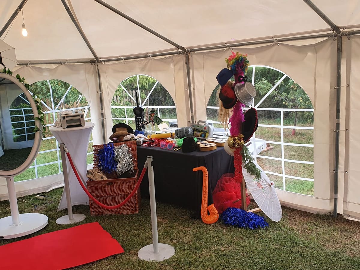 Fotomatón espejo con atrezo bajo una carpa de boda