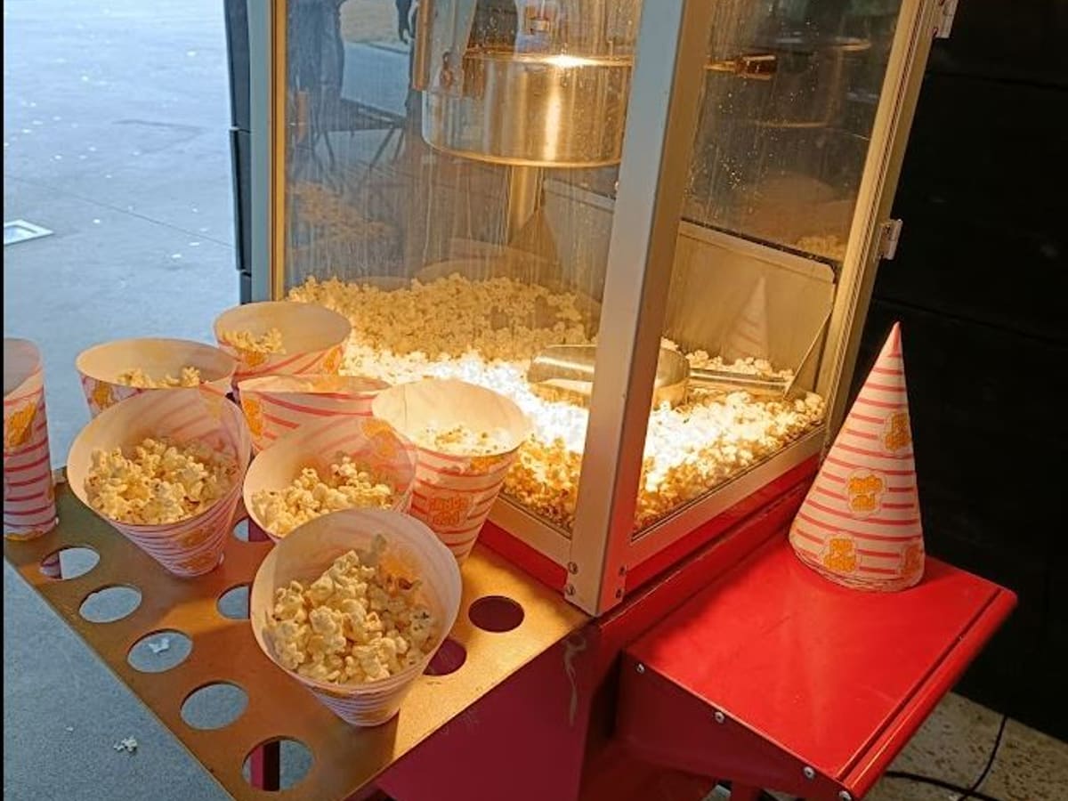 Cucuruchos de palomitas recién hechas delante de la vitrina del carrito