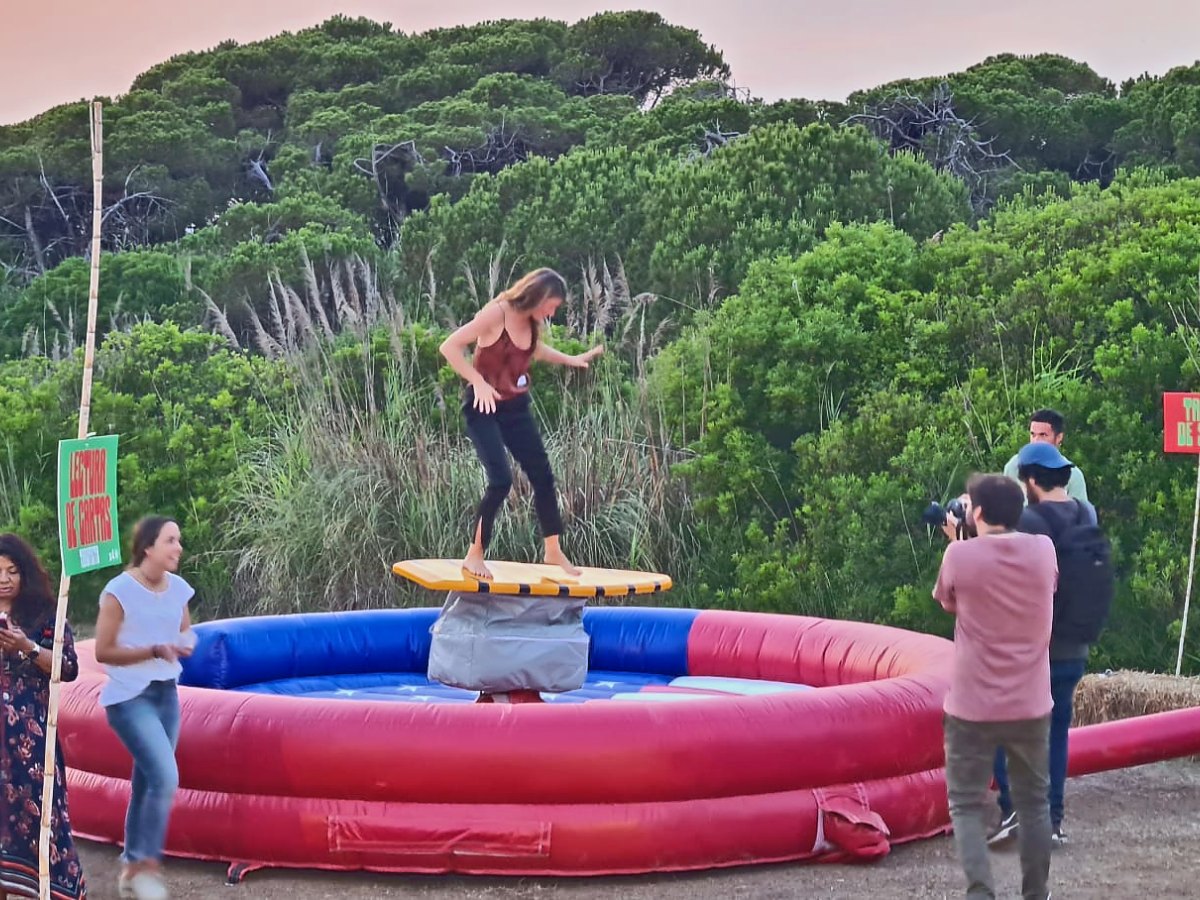 Persona haciendo equilibrio sobre la tabla de surf mecánico en un evento